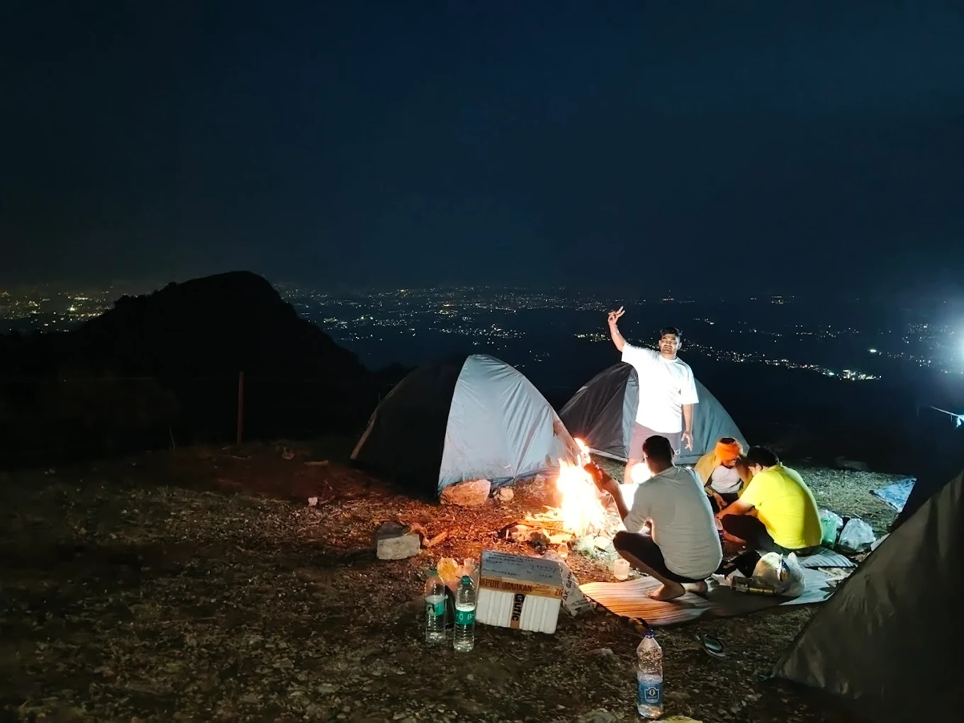 Group around bonfire with city lights