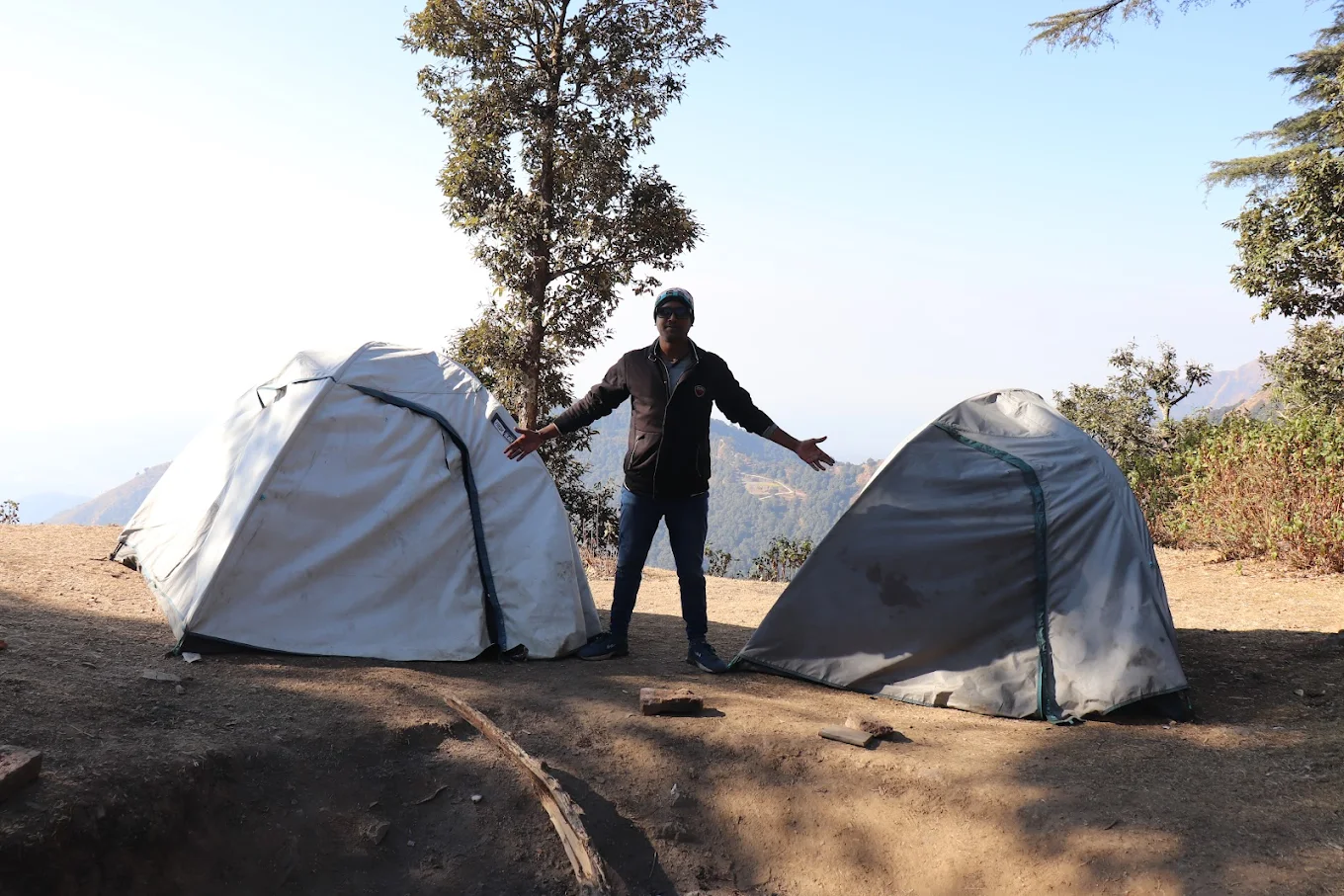 Person between tents with mountain view