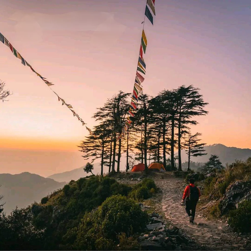 Trekker at sunset with prayer flags